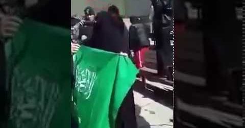 فتاة عربية ترقص على علم السعودية وتلقي نقابها في سلة قمامة