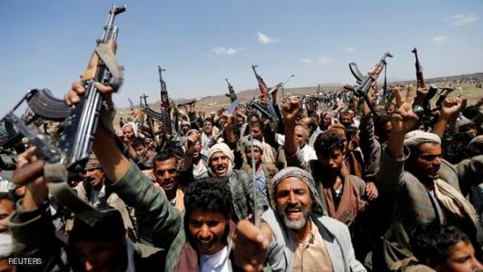 مسلحون حوثيون يرفعون أسلحتهم في اعتصام بإحدى المخيمات في محيط ال